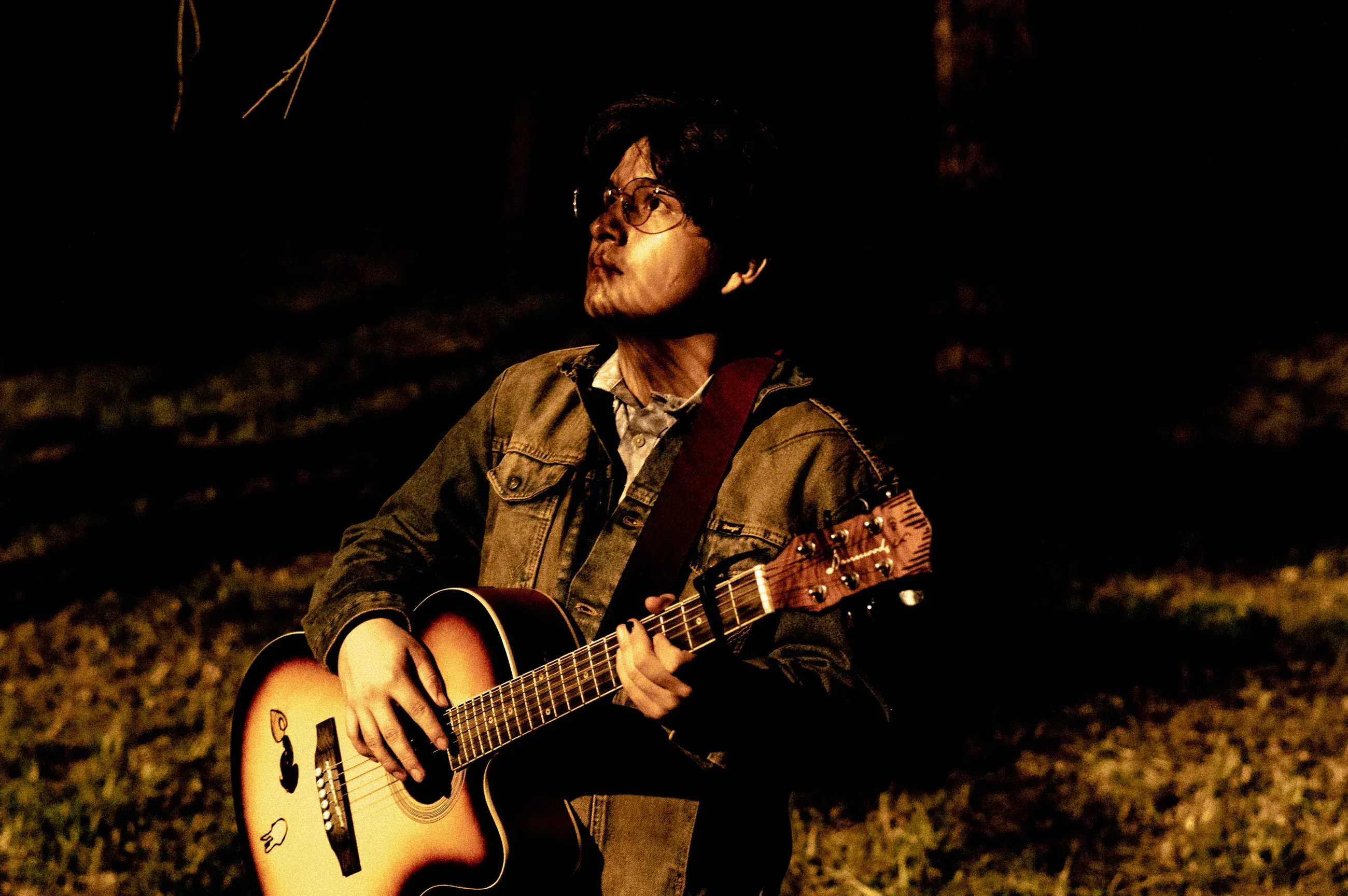 Guille Frank con su guitarra acústica bajo luz ámbar
